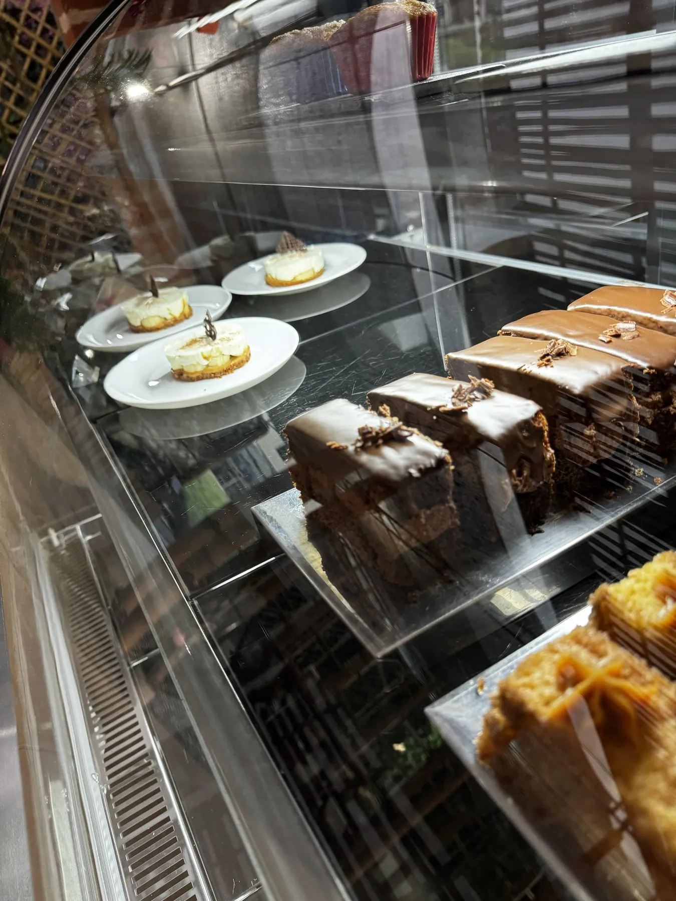 Vitrine com bolos de chocolate, tortas de banana e bolo de cenoura